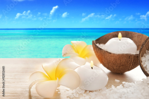 Spa concept of plumeria  coconut and candles with sea salt on seascape background