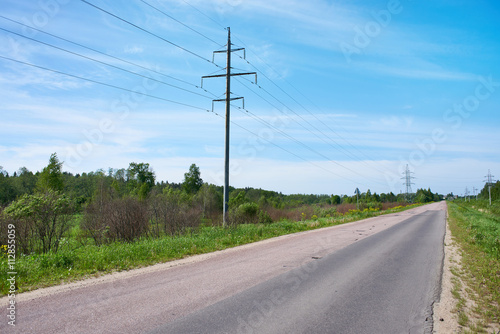High-voltage power line on road landscape