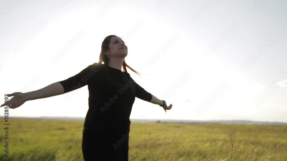 girl bathes in the sun in a field at sunset girl bathes in the sun in a field at sunset