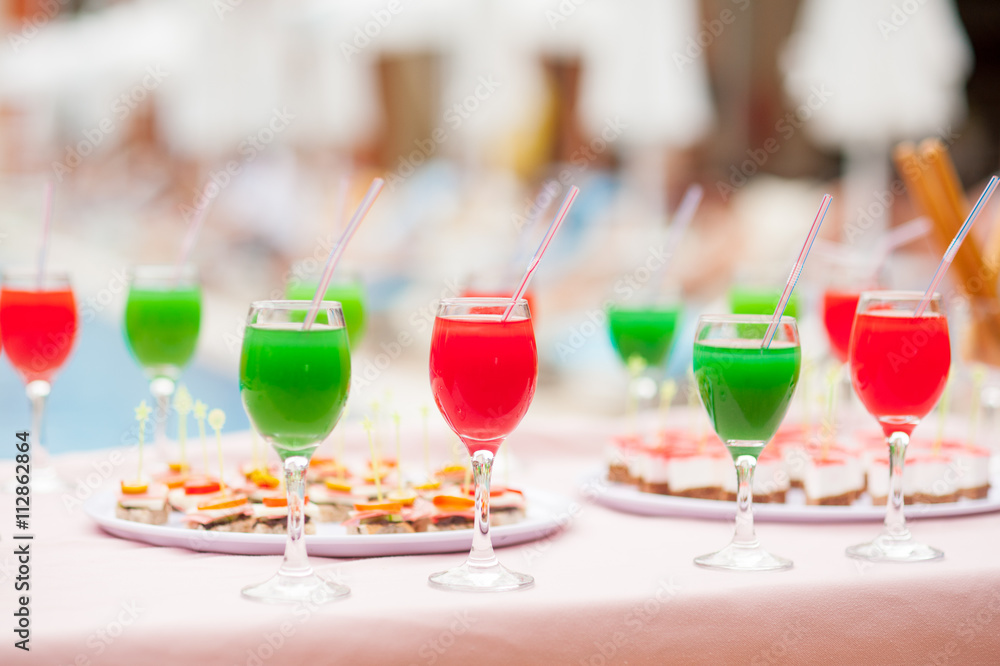 Colourful cocktails and snacks on the table near the pool Colourful cocktails and snacks on the table near the pool