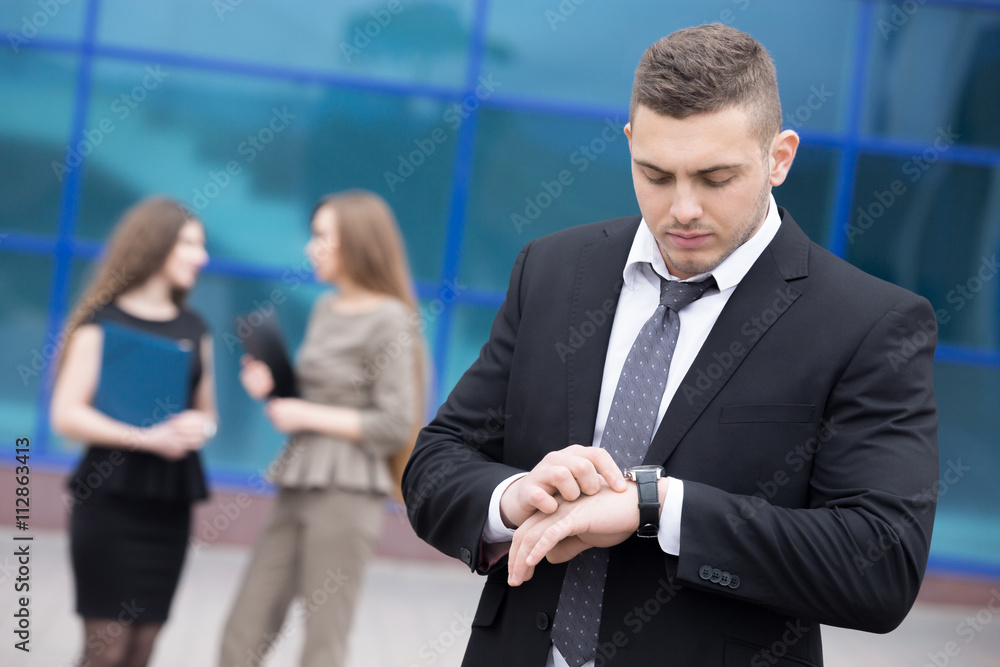 Portrait of young business man looking at watch Portrait of young business man looking at watch