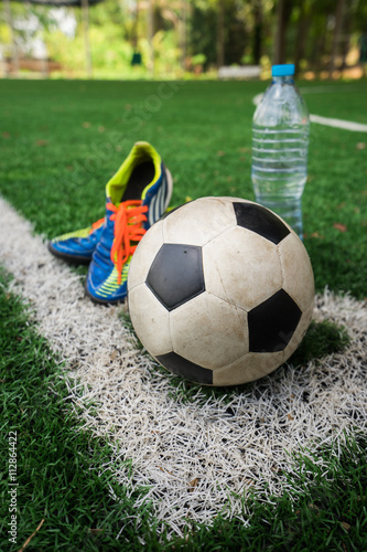 Football cleat and fresh water after the match on the field