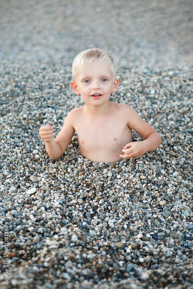 a boy at the seashore pebbles