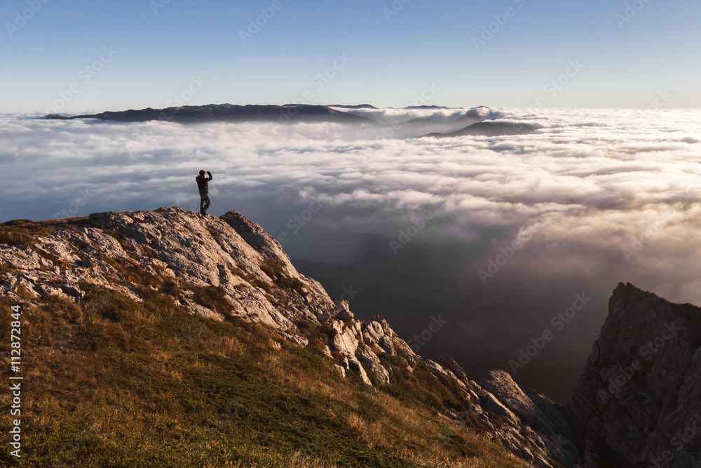 Man standing and watching sunset in the mountains
