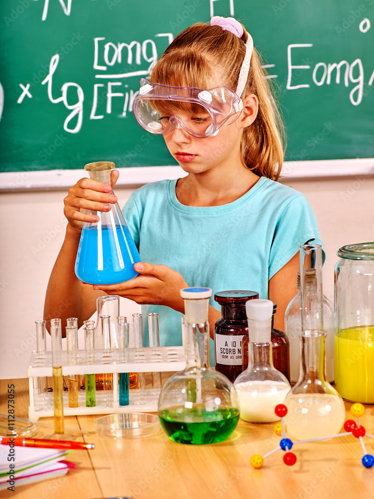 Child in mask holding flask in chemistry class. Chemistry lesson. Child in mask holding flask in chemistry class. Chemistry lesson.