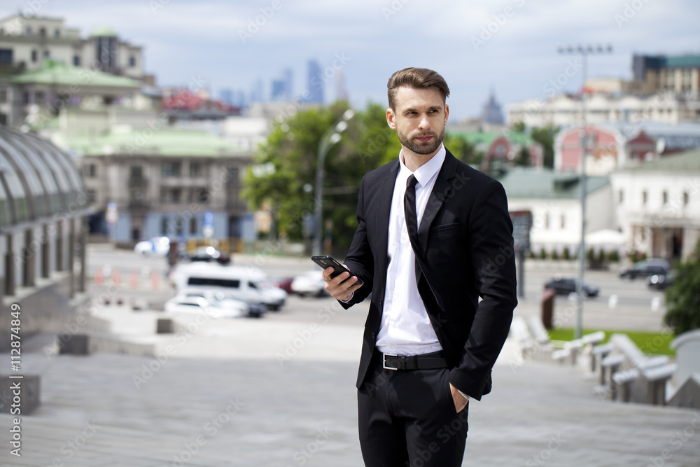 Young successful businessman calling by phone