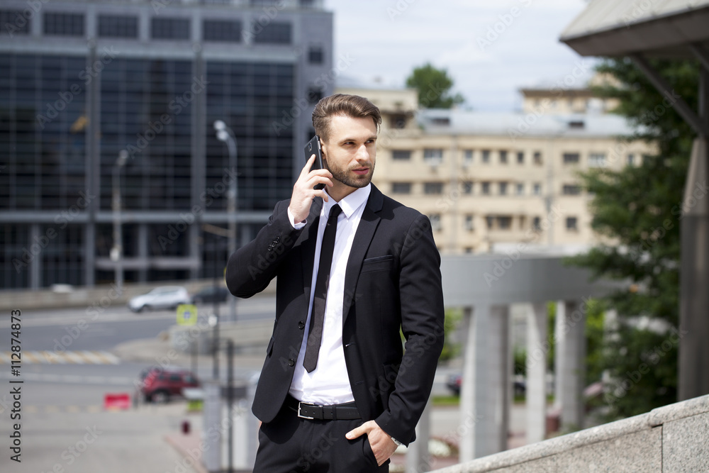Young successful businessman calling by phone Young successful businessman calling by phone