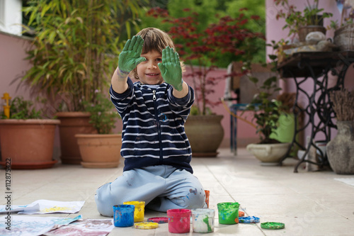 Cutle little boy having fun painting and drawing with colorful finger paints outdoors. Children's creativity, developing imagination and artistic sense, do it yourself concept. photo