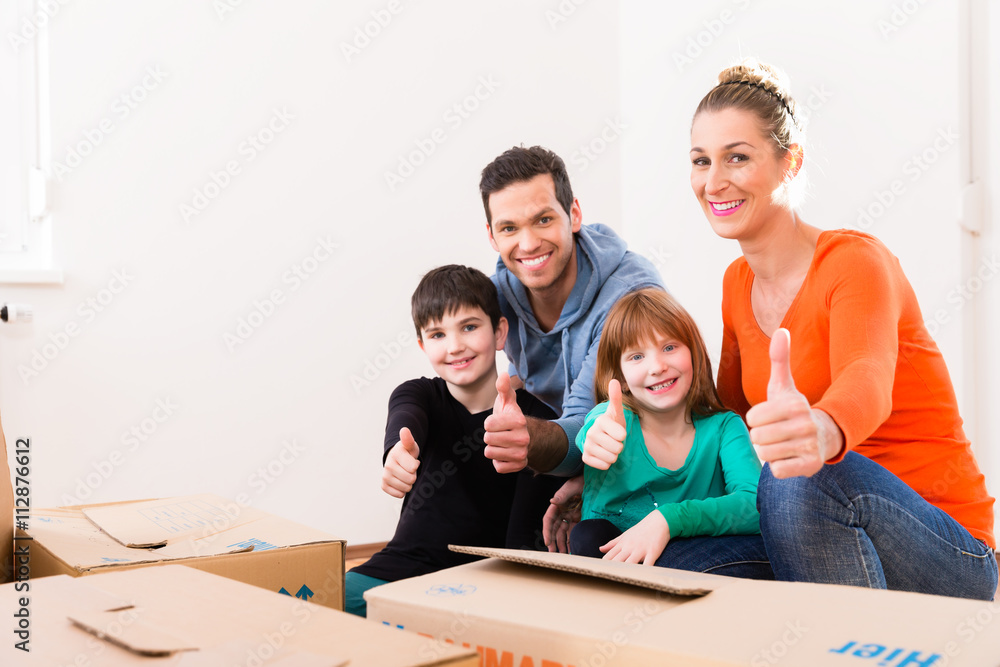 Familie bei Einzug in neue Wohnung oder Haus zeigt Daumen hoch Familie bei Einzug in neue Wohnung oder Haus zeigt Daumen hoch