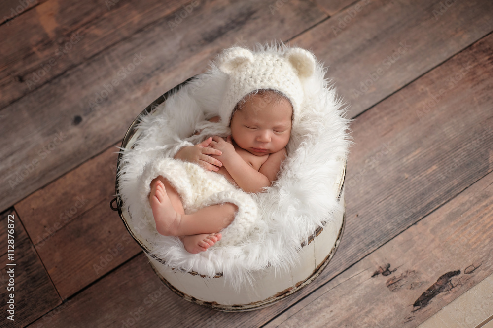 Obraz premium Newborn Girl Wearing a White Bear Hat