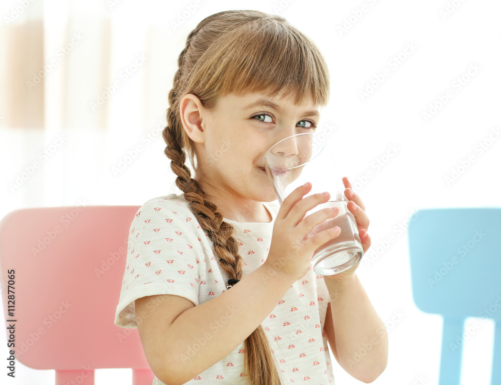 Cute little girl drinking water on light background Cute little girl drinking water on light background