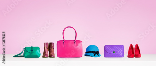 Colorful hand bags,purse,shoes, and hat isolated on pink background. Woman fashion accessories items. Shopping image.  photo