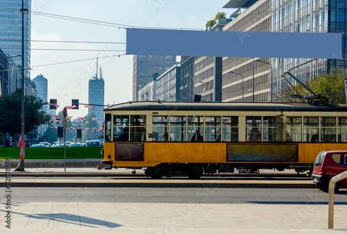 Vintage Yellow tram on modern city background. Milan, Italy.