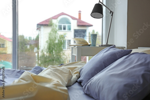 Unmade bed with crumpled bl...