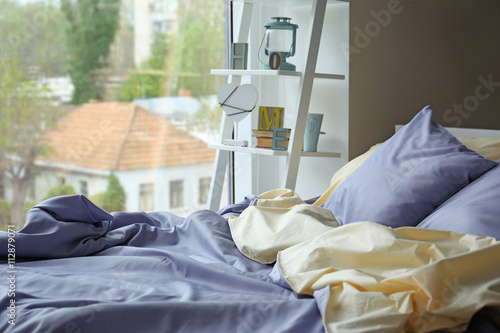 Unmade bed with crumpled bl...