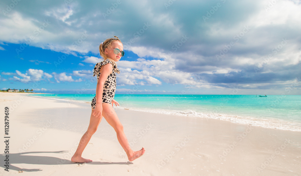 Adorable little girl at shallow water on the beach
