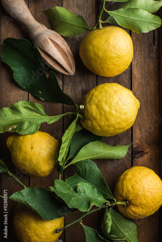 Fresh lemons with leaves in rustic wooden box