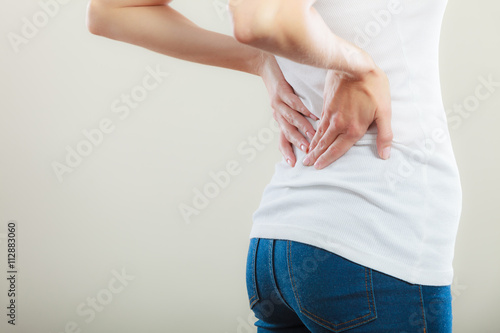Backache. Young woman suffering from back pain photo
