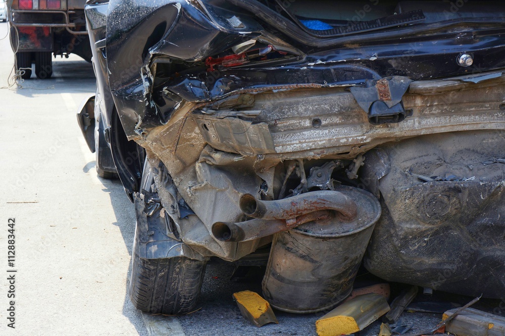 Demolished Rear Part of Dark Car after Accident. Destroyed Body, damaged tires, exhausting pipe, luggage space, bumper.