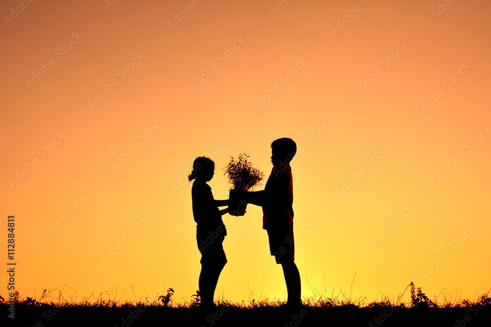 Silhouette children holding plant at sky sunset. Concept save world