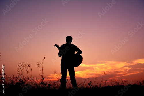 Silhouette man with guitar in the sunset