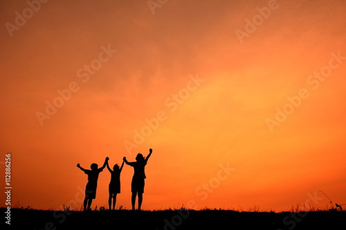 Silhouette women and children open hand in the sunset