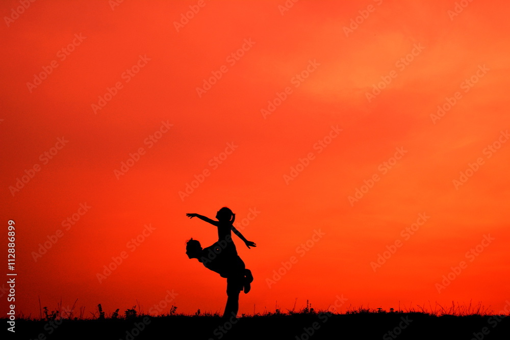 Silhouette mother and daughter in the sunset
