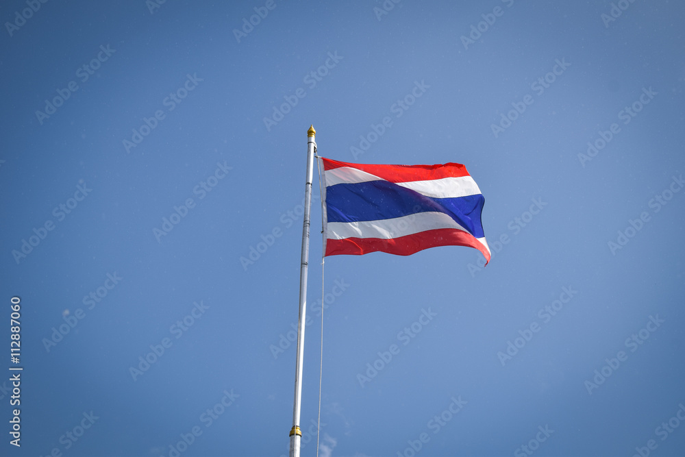 Thai flag of Thailand on rainy day with blue sky background