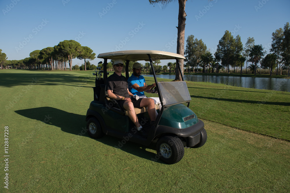 golf players driving cart at course golf players driving cart at course