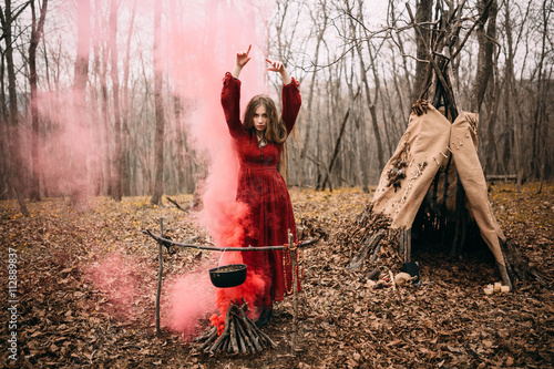 Foto Young witch in the autumn forest
