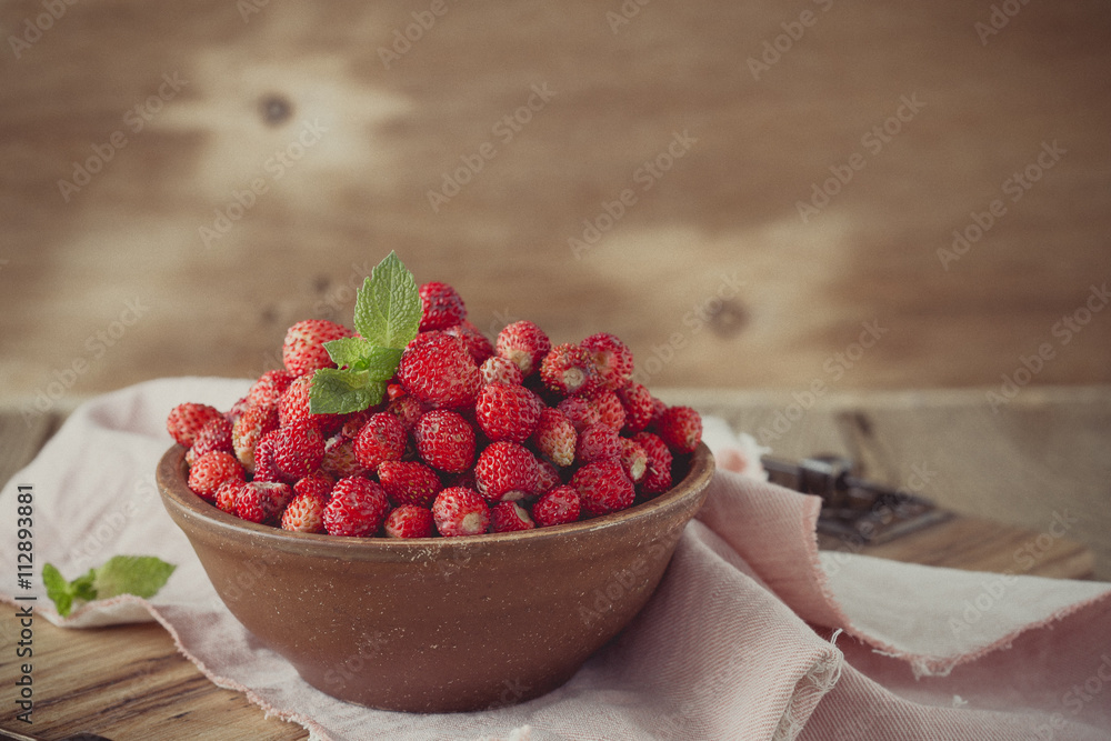 Wild strawberries in ceramic bowl in retro style Wild strawberries in ceramic bowl in retro style