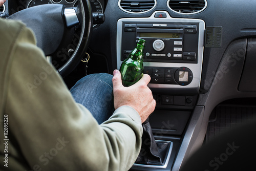 Man drinking alcohol in the car.