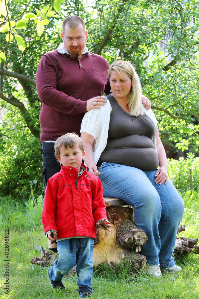 Obraz premium Obese farmer's family together on garden. Pregnant mother and overweight father. People working and enjoying life on countryside. Pregnancy and parenting.