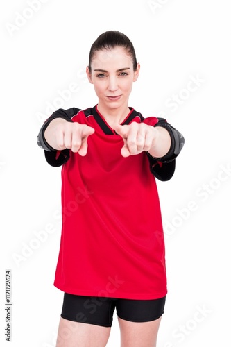 Female athlete posing with elbow pad and pointing the camera