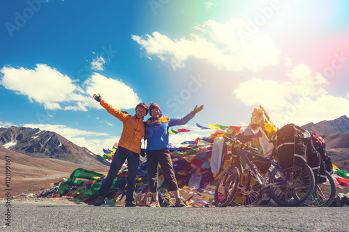 Young happy friends cyclists standing on road in Himalayas mountains  photo