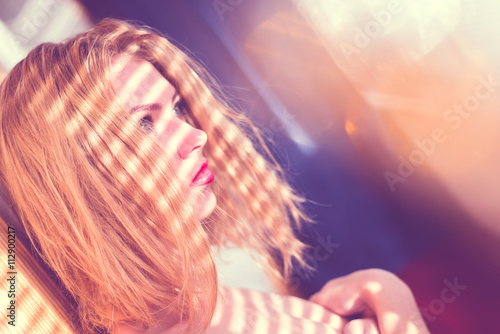 purity of miracle flare girl: close up on elegant blue eyes lady with shadow from window blinds on shoulders having fun looking at sun light flare rays on light copy space background portrait image