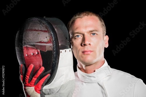 Close-up of swordsman holding fencing mask photo