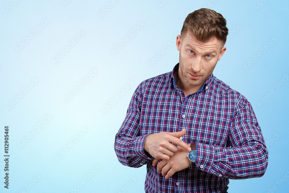 Handsome astonished young business man pointing on watch Handsome astonished young business man pointing on watch
