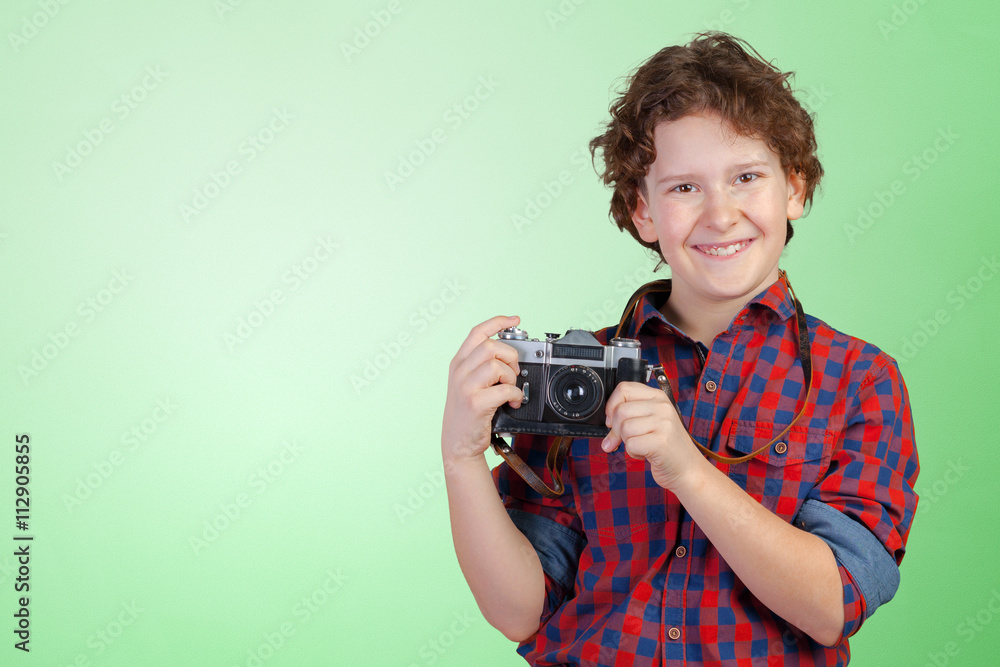 Cheerful smiling child (boy) holding a instant camera Cheerful smiling child (boy) holding a instant camera