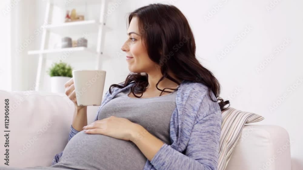 happy pregnant woman with cup drinking tea at home happy pregnant woman with cup drinking tea at home