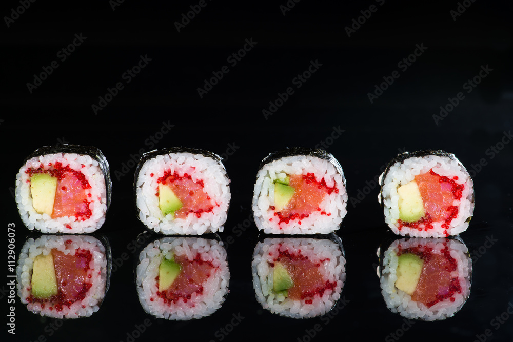 close-up of sushi with salmon and avocado on a dark background w close-up of sushi with salmon and avocado on a dark background w