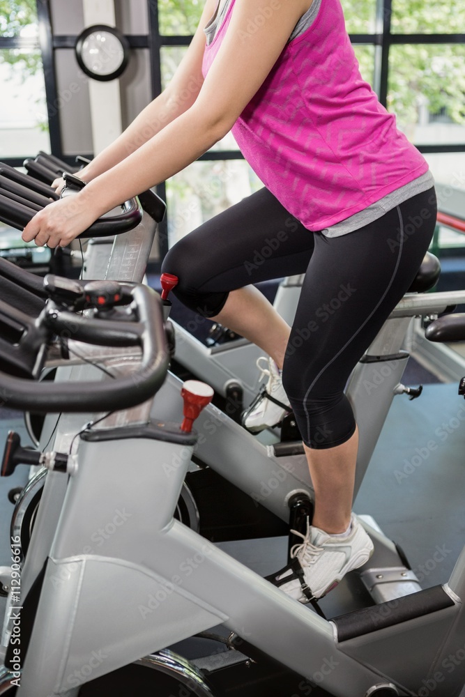 Woman working out on exercise bike at spinning class Woman working out on exercise bike at spinning class