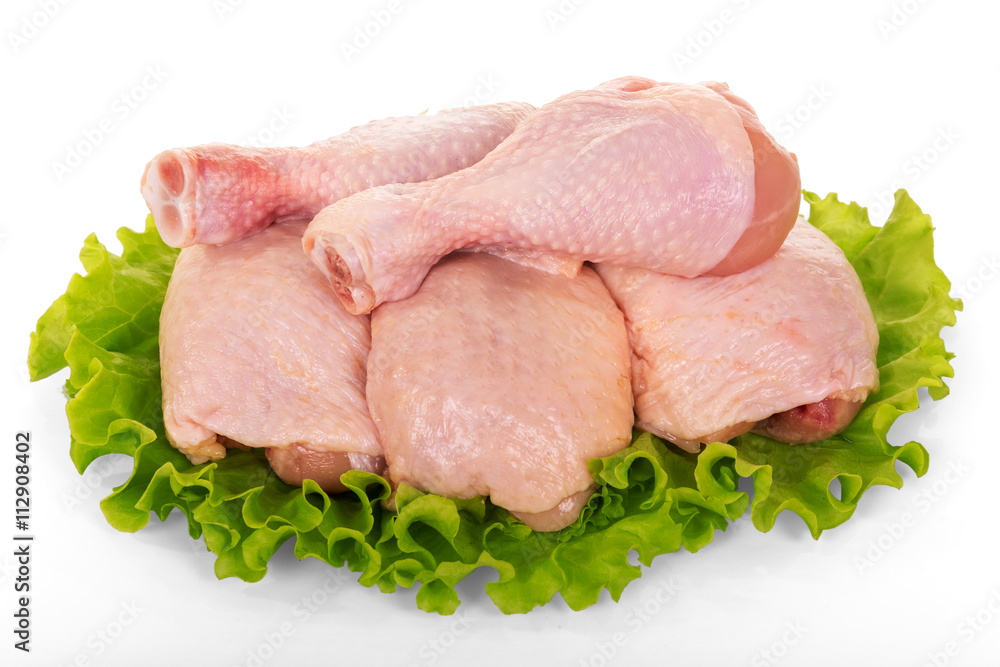 Raw chicken legs and lettuce isolated on white.
