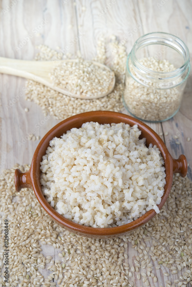 Cooked steamed rice in a blue bowl over wooden background Cooked steamed rice in a blue bowl over wooden background