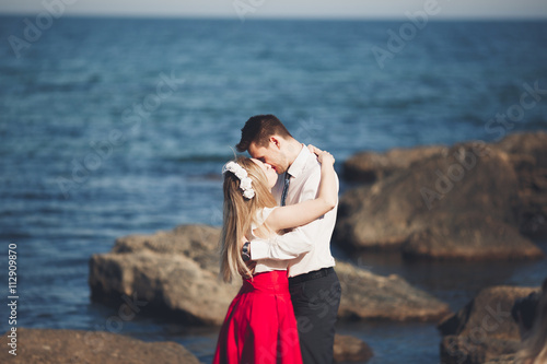 Charming bride, elegant groom on landscapes of mountains and sea Gorgeous wedding couple