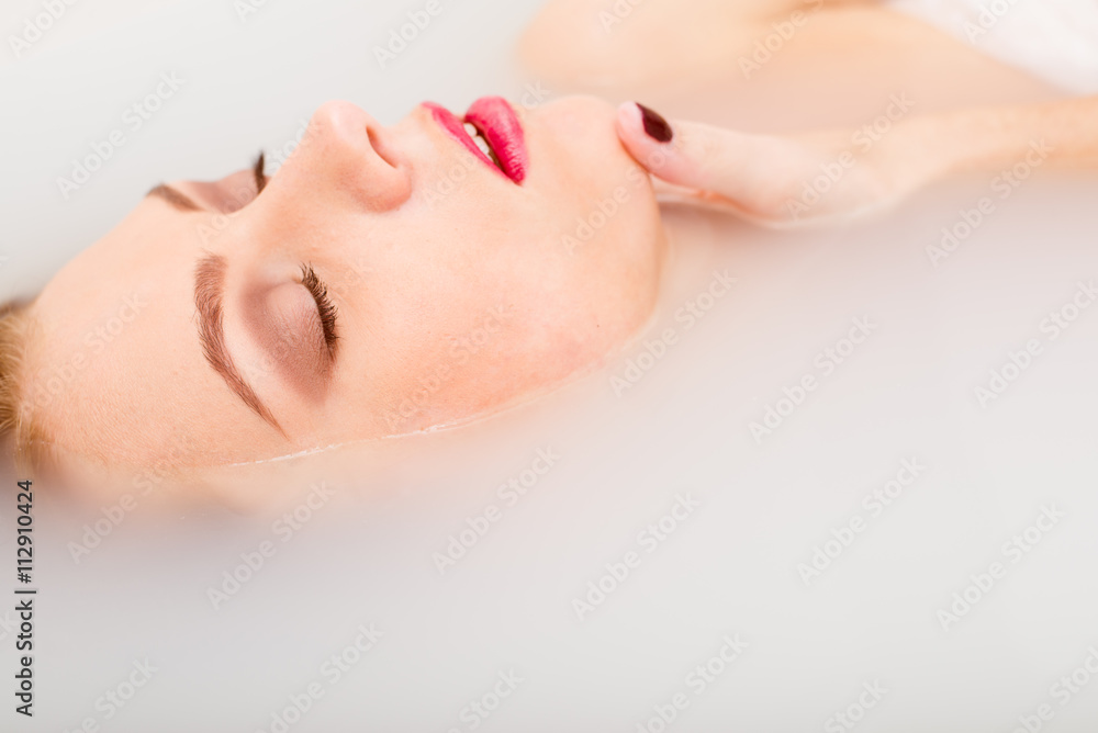 sleeping beauty in spa: closeup portrait of sexy elegant pinup girl with silk skin having fun happy relaxing lying in milk water on copy space background sleeping beauty in spa: closeup portrait of sexy elegant pinup girl with silk skin having fun happy relaxing lying in milk water on copy space background