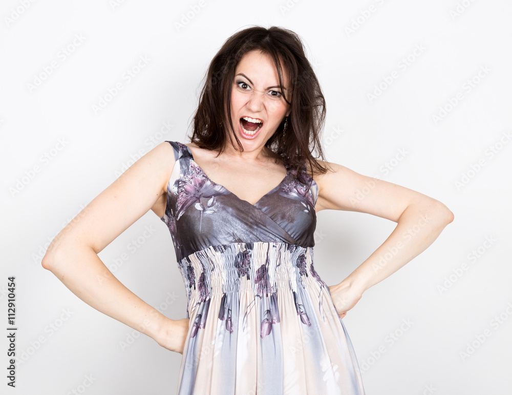 beautiful young brunette woman in a colorful dress posing and expresses different emotions. disturbance, anger. close-up portret beautiful young brunette woman in a colorful dress posing and expresses different emotions. disturbance, anger. close-up portret