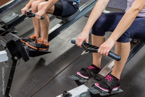 Mid section of people exercising on rowing machine