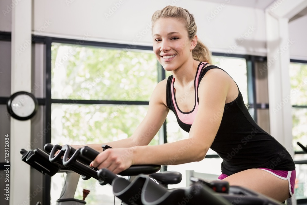 Fototapeta premium Woman sitting on exercise bike
