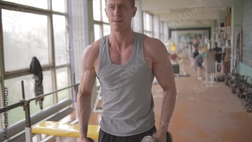 Young athletic man training in old soviet gym. Ungraded photo